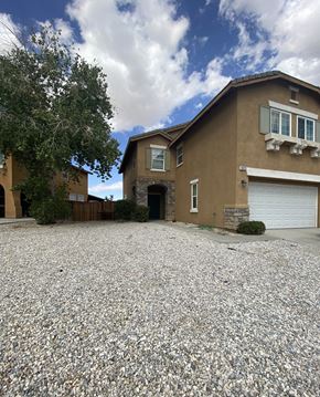 Victorville house for rent - A house with a gravel driveway in front.