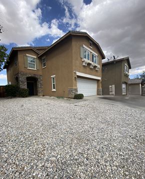 Victorville house for rent - A house with a gravel driveway in front.