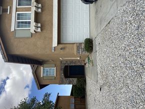 Victorville house for rent - A house with a brown exterior and a white garage door.