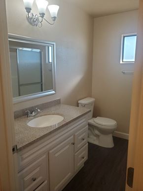 Ontario apartment for rent - a bathroom with a toilet and a sink and a mirror