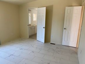 Adelanto house for rent - A room with a marble floor and two white doors.