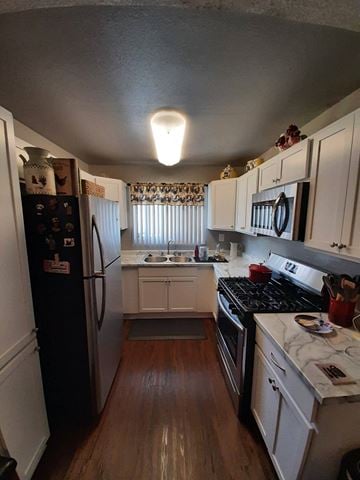 Paramount apartment for rent - A kitchen with a black fridge and white cabinets.