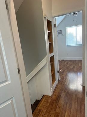 Pomona house for rent - a small room with a staircase and a book shelf in it