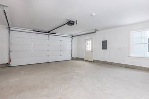 Brunswick apartment for rent - A spacious garage with a white door and a window.