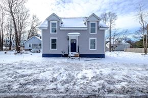South Portland apartment for rent - A house with a blue door and windows is surrounded by snow.