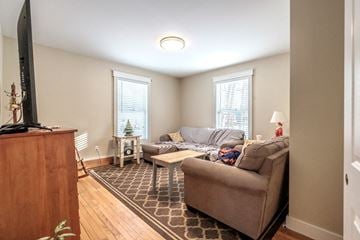 South Portland apartment for rent - A living room with a brown couch and a wooden cabinet.
