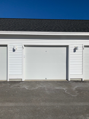Scarborough apartment for rent - Two white garage doors on a building.
