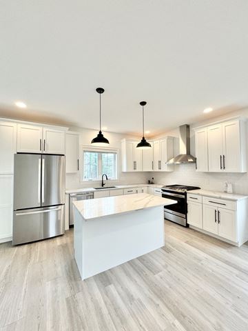 Scarborough townhouse for rent - a large white kitchen with white cabinets and stainless steel appliances
