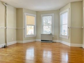 Portland apartment for rent - an empty living room with wood floors and three windows