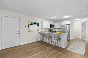 Westbrook apartment for rent - a kitchen with white cabinets and a island with two stools
