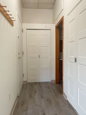 Portland apartment for rent - a bedroom with white doors and a hallway with wood floors