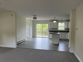 Gorham apartment for rent - A spacious kitchen and living room with a sliding glass door leading to a backyard.