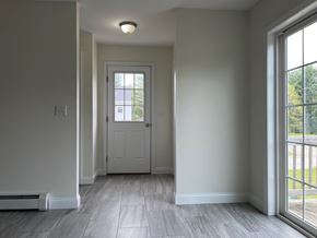 Gorham apartment for rent - A white door is in the middle of a hallway with a light on the ceiling.