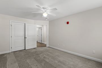 Brunswick apartment for rent - the living room of an apartment with carpet and a ceiling fan