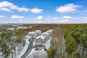 Westbrook apartment for rent - arial view of snow covered buildings in the middle of a forest
