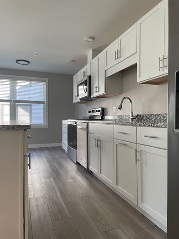 Scarborough condo for rent - A kitchen with white cabinets and a grey countertop.