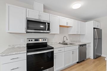 Scarborough apartment for rent - A kitchen with white cabinets and a black oven.