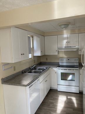 Gorham apartment for rent - an empty kitchen with white cabinets and stainless steel appliances