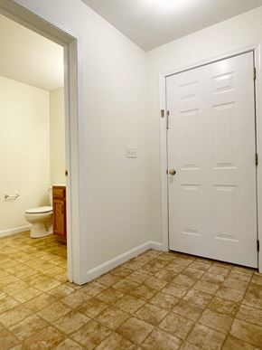 Buxton triplex for rent - A white door is closed in a room with a tiled floor.
