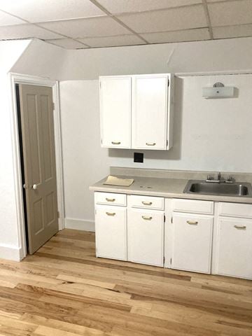 Portland apartment for rent - an empty kitchen with white cabinets and a sink