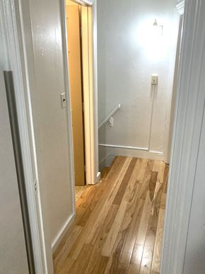 Portland apartment for rent - a small hallway with wood flooring and a staircase