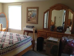 Portland apartment for rent - A bedroom with a bed, dresser, mirror, and a painting on the wall.