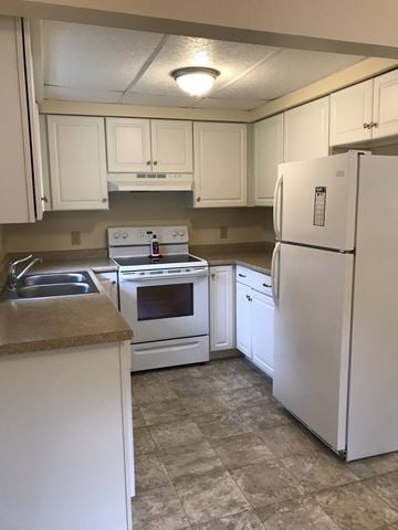 Gorham apartment for rent - a kitchen with white appliances and white cabinets