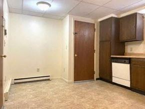 Gorham apartment for rent - an empty kitchen with a stove and a refrigerator
