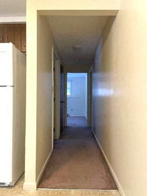 Gorham apartment for rent - a long hallway with a refrigerator and a door