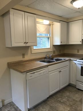Gorham apartment for rent - an empty kitchen with white cabinets and a sink