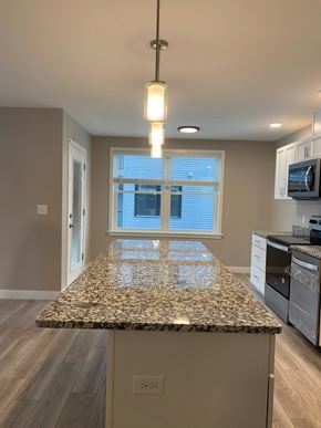 Scarborough condo for rent - A kitchen with granite countertops and a window with blinds.