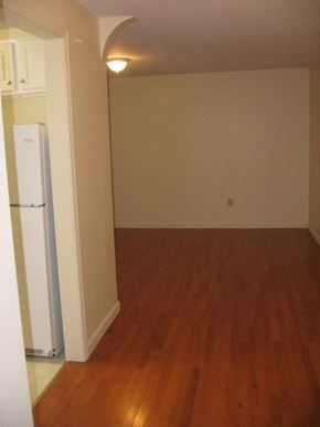 Portland apartment for rent - an empty living room with a refrigerator in it