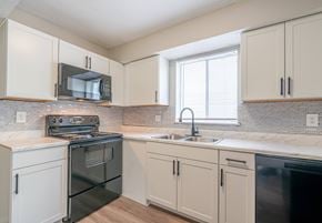 Jacksonville apartment for rent - A kitchen with a black oven and white cabinets.