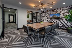 Milpitas apartment for rent - a meeting room with a large table and chairs and a mural on the wall