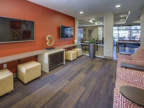 Tustin apartment for rent - a room with couches and chairs and a television on the wall