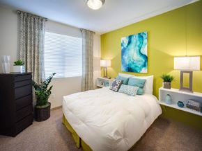 Tustin apartment for rent - a bedroom with a large bed in front of a green wall