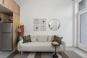 Sacramento apartment for rent - A living room with a white couch and a grey refrigerator.