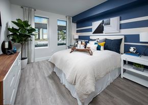 Milpitas apartment for rent - a bedroom with a large bed with white and blue bedding and a blue and white striped