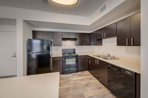Irvine apartment for rent - a kitchen with dark wood cabinets and stainless steel appliances