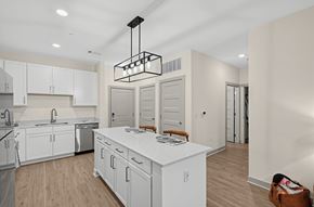 Charlestown apartment for rent - A modern kitchen with white cabinets and a wooden island.