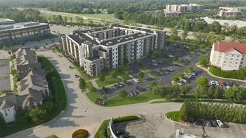 Louisville apartment for rent - A large building with a parking lot in front of it.