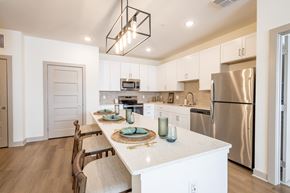 Whitestown apartment for rent - A modern kitchen with a long table and chairs.