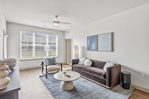Bowling Green apartment for rent - A living room with a brown couch, a white coffee table, and a ceiling fan.