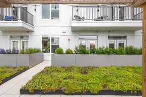 Clarksville apartment for rent - A white building with a green planter in front at Current812, Clarksville