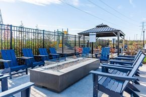 Jeffersonville apartment for rent - A gazebo is surrounded by blue chairs and a fire pit at The Warren Apartments, Jeffersonville, IN