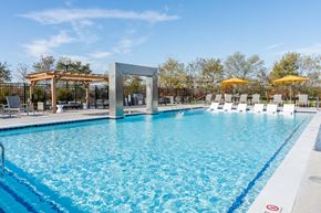 Jeffersonville apartment for rent - A large swimming pool with a blue tinted water and a white line around it at The Warren Apartments, Jeffersonville, IN