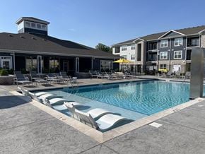 Bowling Green apartment for rent - A pool with lounge chairs and a building in the background.