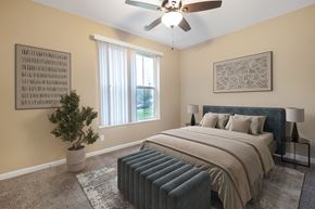 Louisville apartment for rent - A bedroom with a bed, a ceiling fan, and a potted plant.