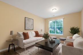 Louisville apartment for rent - A living room with a white couch, a coffee table, and a small potted plant.