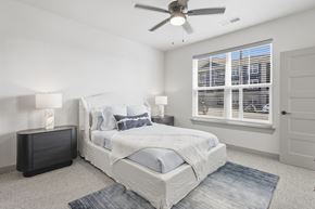 Jeffersonville apartment for rent - A bedroom with a large bed, a ceiling fan, and a window with blinds at The Warren Apartments, Jeffersonville, IN